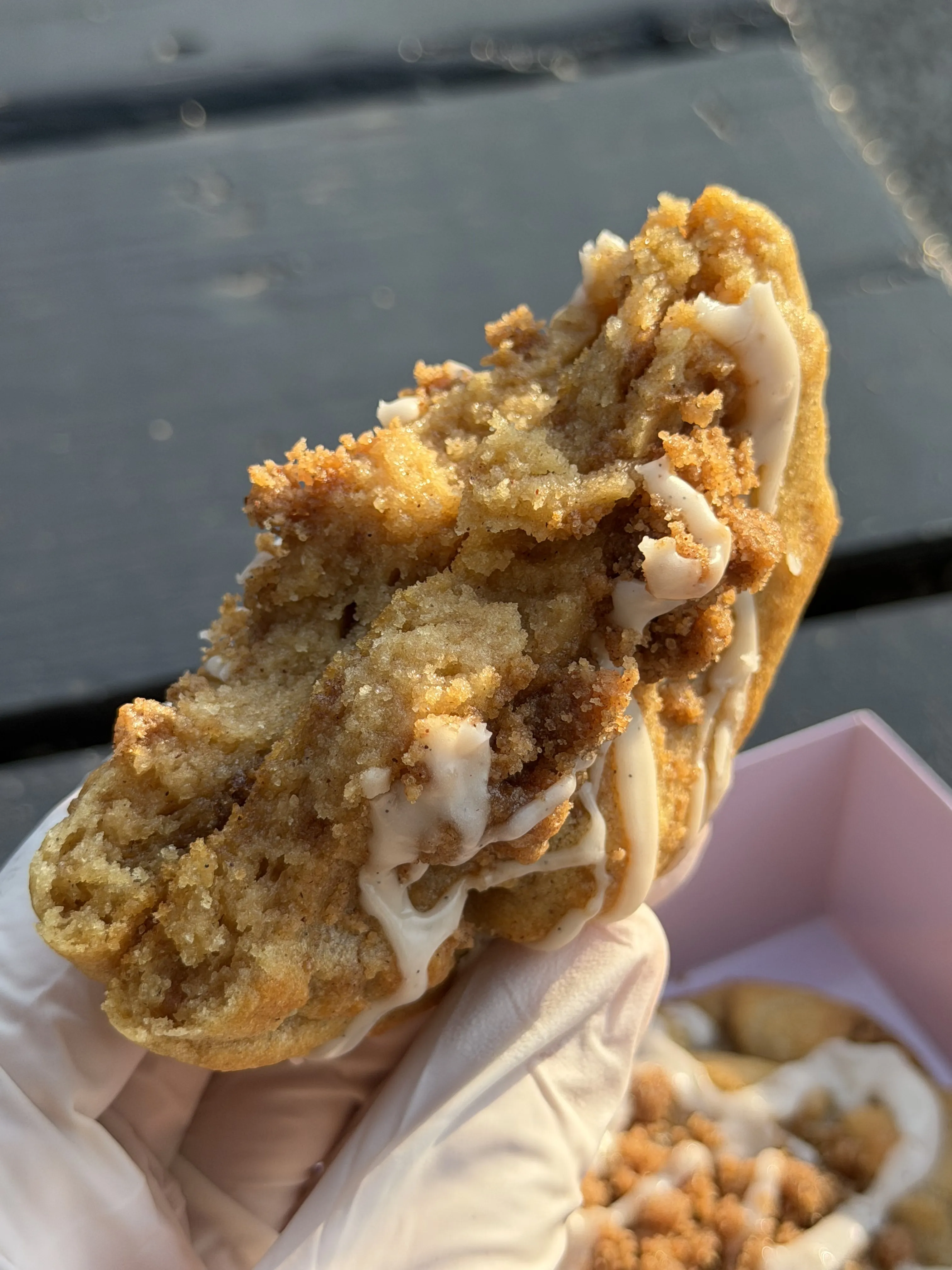 Crumb-topped cookie broken open to show a soft layered center.