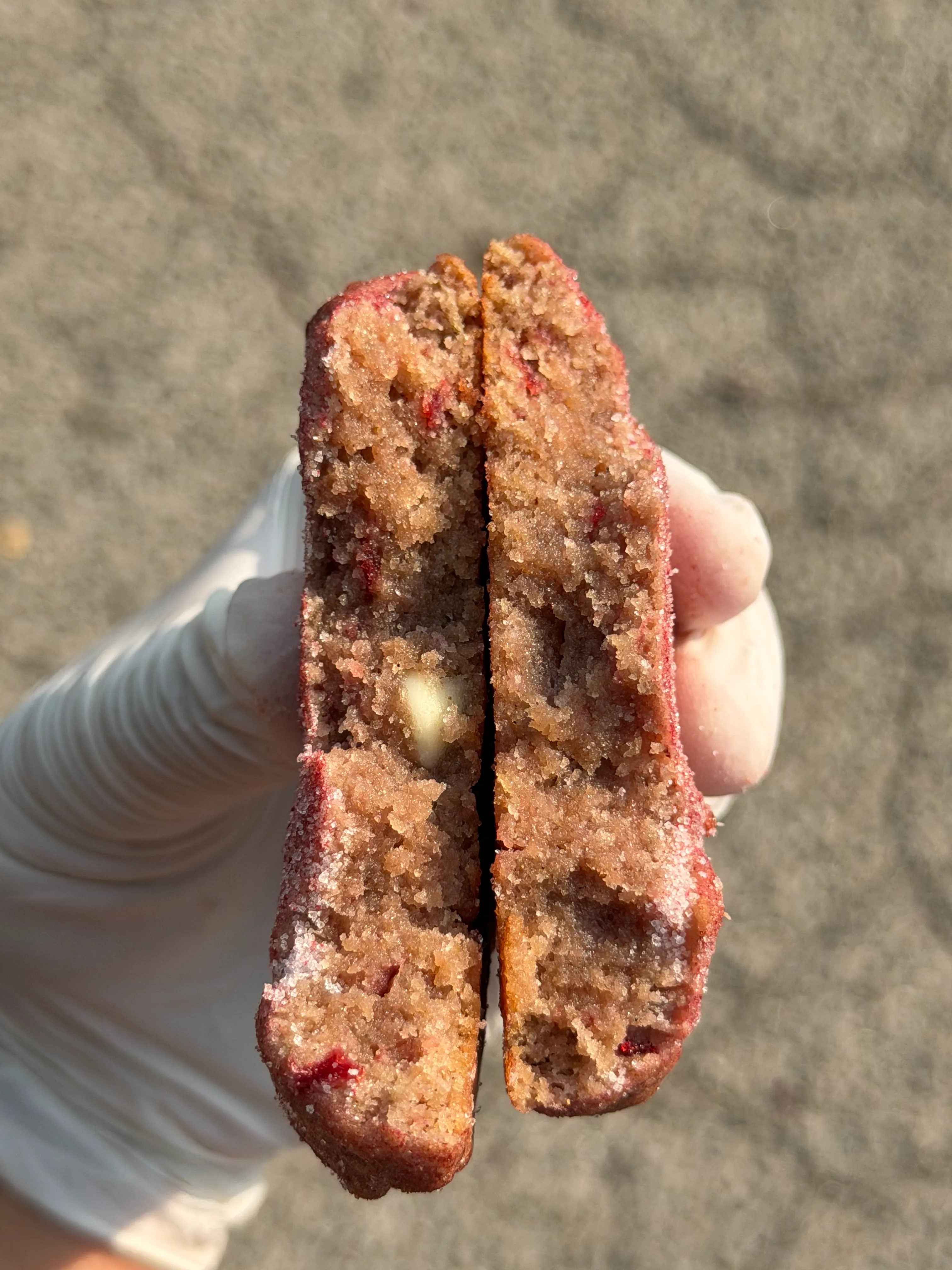 A red-toned cookie broken open to show its soft filled center.